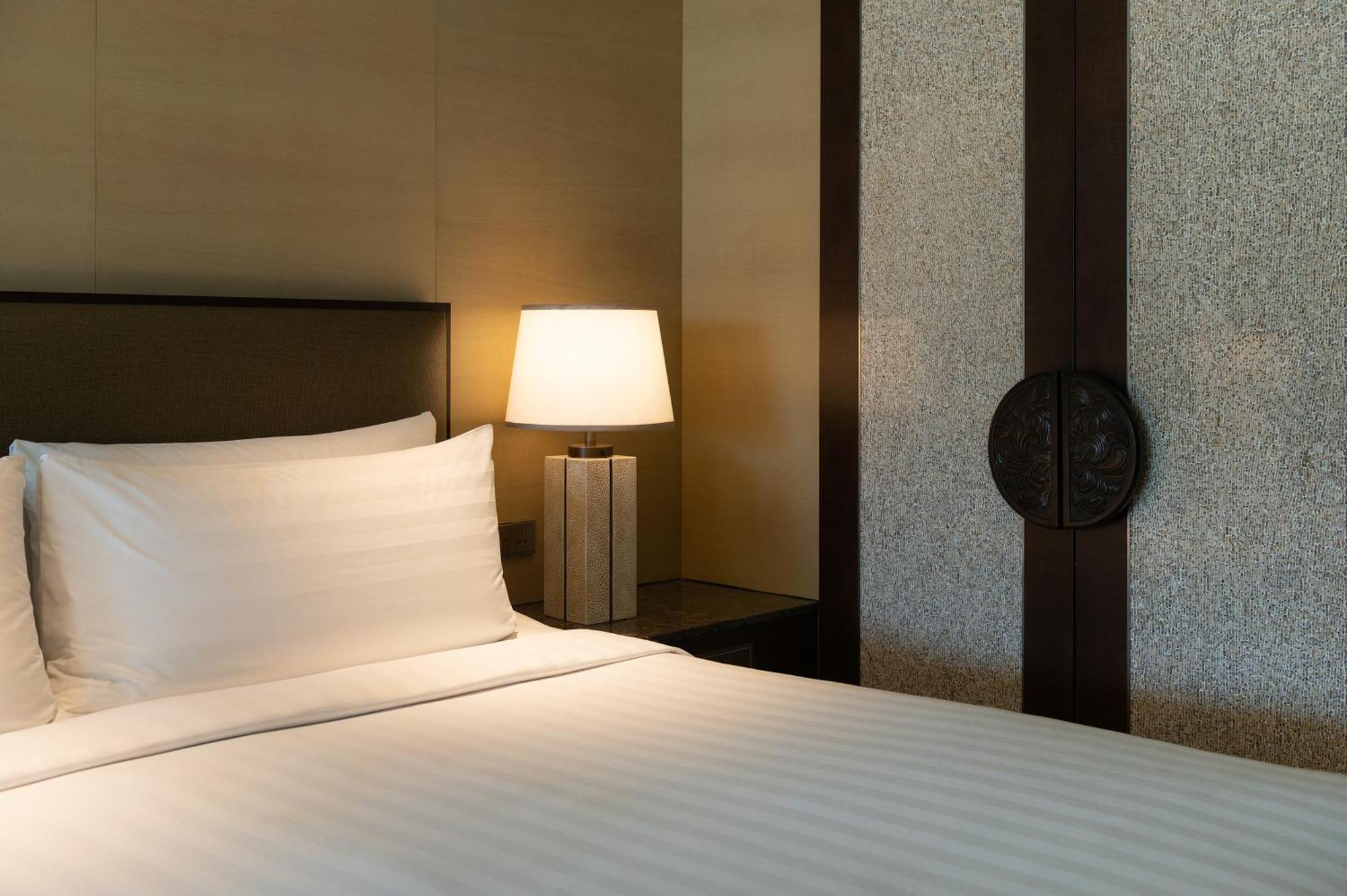 Shangri-La Tanjung Aru, Kota Kinabalu Esterno foto A bed with a nightstand and a lamp